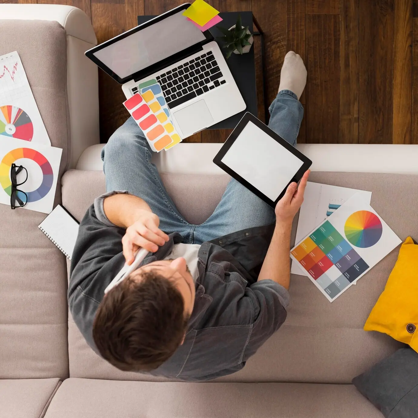 Вид сверху на неформально одетого мужчину, работающего из дома.